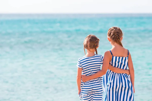 Rückansicht von zwei Mädchen am Strand Hintergrund blaues Meer — Stockfoto