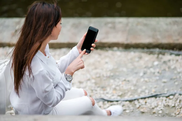 女性的手的特写持有手机在户外在大街上。使用手机的人. — 图库照片