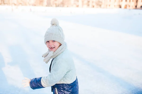 Adorable little girl going skate in winter snow day outdoors — Stock Photo, Image