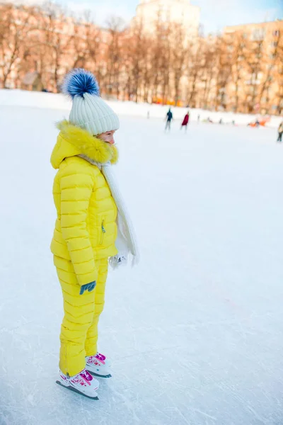 Little girl skating on the ice rink outdoors enjoy winter day — Stock Photo, Image