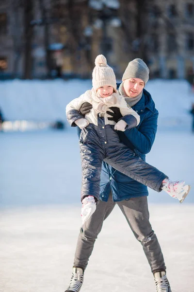 Padre y adorable niña divirtiéndose en pista de patinaje al aire libre — Foto de Stock