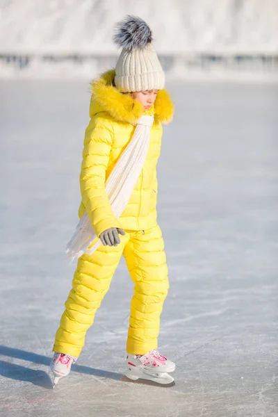 Adorable petite fille patinant sur la patinoire à l'extérieur — Photo