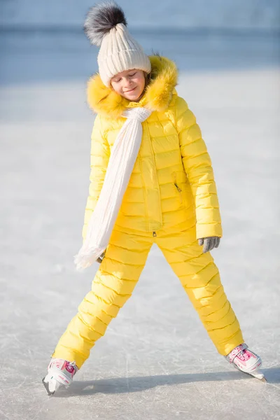 Adorable little girl skating on the ice rink outdoors — Stock Photo, Image