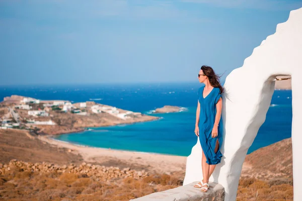 Ung kvinna och traditionell vit kyrka med havsutsikt på ön Mykonos, Grekland — Stockfoto