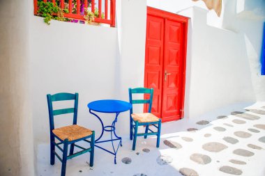 Mavi sandalye ve Mykonos Adası, Yunanistan, Avrupa konusunda Beyaz evleriyle tipik Yunan geleneksel köy Caddesi üzerinde tablo