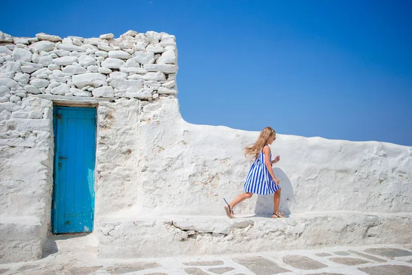 Cute girl in blue dress having fun outdoors near Paraportiani church. — Stock Photo, Image