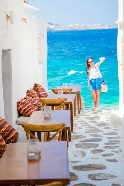 Прекрасним видом на море в придорожньому кафе Mykonos на Крит. Молода жінка, беручи selfie з видом на цей дивовижний — стокове фото