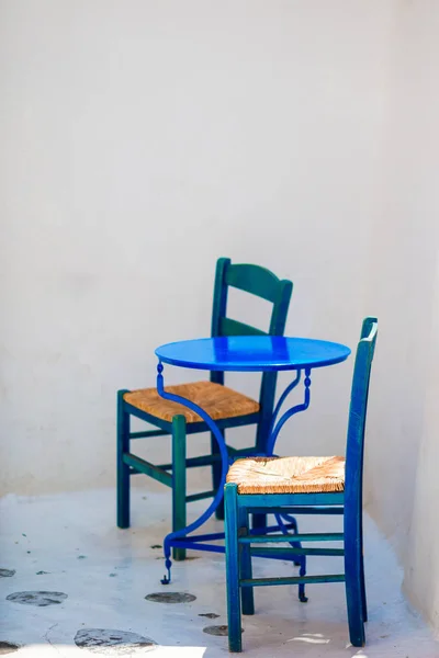 青い椅子とテーブル ミコノス島、ギリシャ、ヨーロッパの典型的なギリシャの伝統的な村の通りを — ストック写真