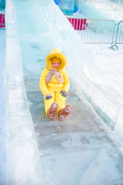 Bedårande liten flicka som rider på en is-hill utomhus — Stockfoto