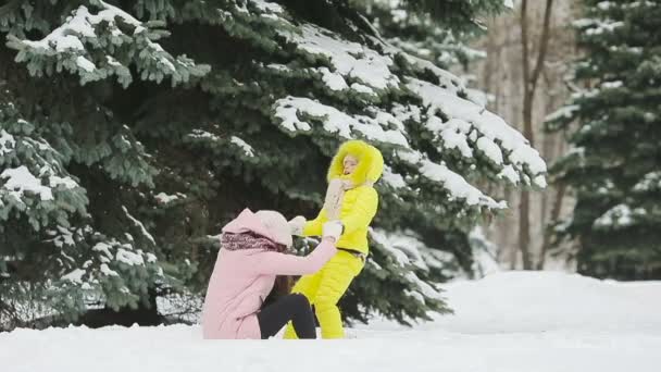 Familie van twee genieten van winterse besneeuwde dag en sneeuwballen buiten spelen — Stockvideo