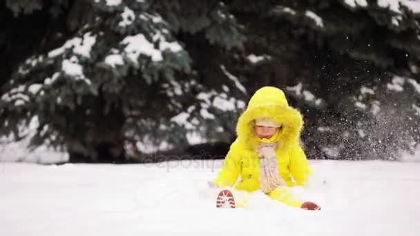 Bedårande liten tjej att ha kul på vinter dag utomhus och leka snöbollar — Stockvideo