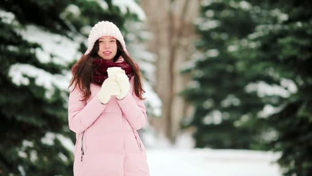 Νεαρή γυναίκα στο χιόνι καιρικές συνθήκες σε εξωτερικούς χώρους με καφέ να πάει σε όμορφη μέρα του χειμώνα — Αρχείο Βίντεο