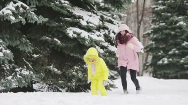 Genç anne ve açık havada kartopu oynarken