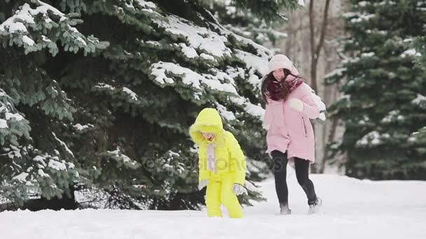 Junge Mutter und Schneebälle spielen im Freien — Stockvideo