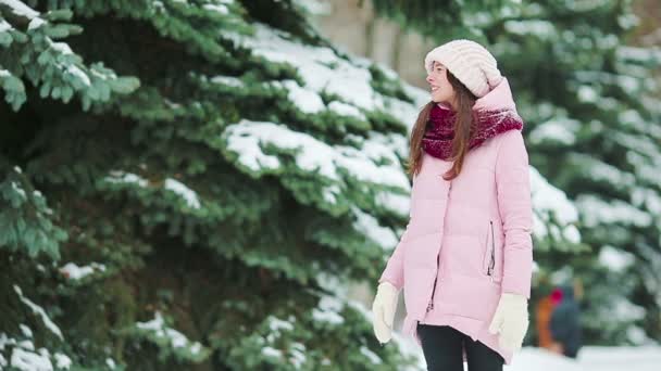 Молодая женщина в снежную погоду на открытом воздухе в прекрасный зимний день — стоковое видео