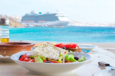 Deniz Manzaralı açık Cafe'de öğle yemeği için lezzetli taze Yunan salatası ve brusketa ile geleneksel yemek hazır