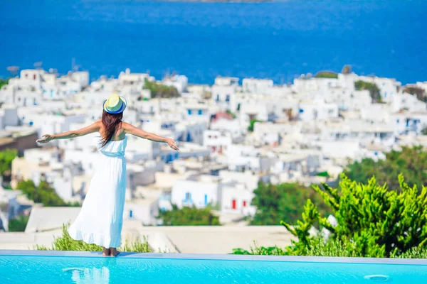 Щасливі дівчину відчути свободу розслабляючий на краю басейну з чарівним видом на Міконос, Греція — стокове фото