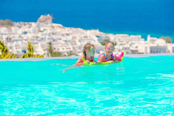 Adorable little girls playing in outdoor swimming pool with beautiful view — Stock Photo, Image