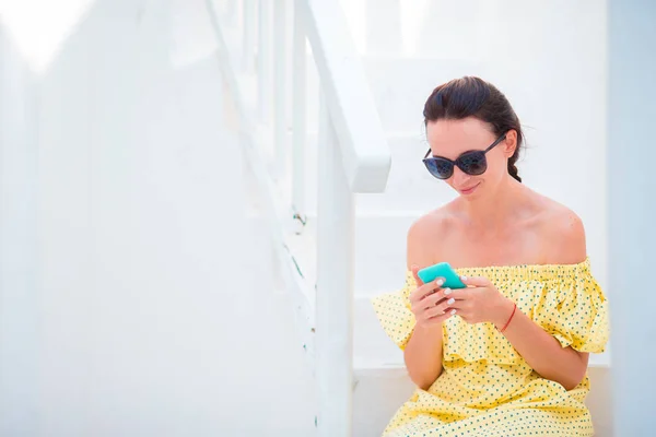 Mulher com smartphone ao ar livre na estreita rua velha. Turista usando smartphone móvel . — Fotografia de Stock