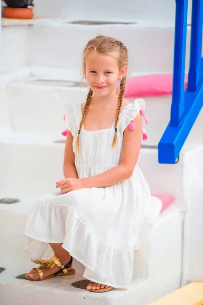 Adorable little girl at street of typical greek traditional village on Mykonos Island, in Greece — Stock Photo, Image