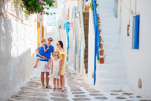 Family vacation in small european city. Parents and kids at street of greek traditional village on Mykonos Island — Stock Photo, Image