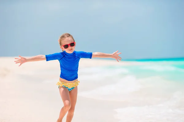 Entzückendes kleines Mädchen während des Strandurlaubs mit Spaß im flachen Wasser — Stockfoto