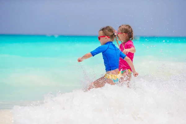 Niños divirtiéndose en la playa tropical jugando juntos en aguas poco profundas — Foto de Stock