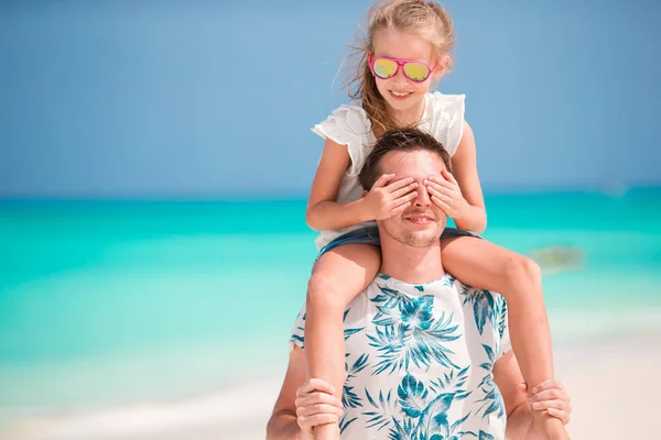 Щасливий батько і його чарівна маленька дочка на тропічному пляжі розважаються — стокове фото