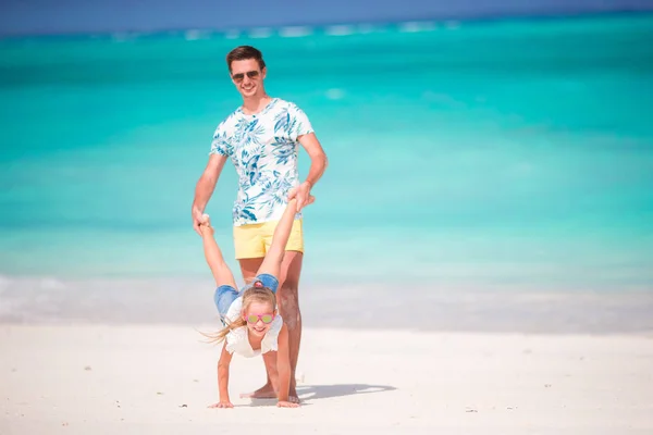Šťastný otec a jeho roztomilé dcerušky na tropické pláži baví — Stock fotografie