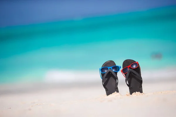 Schwarze Flip-Flops mit Sonnenbrille am weißen Strand — Stockfoto