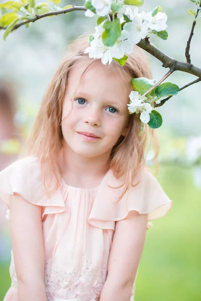 Retrato de niña adorable en el jardín de manzanos en flor en el día de primavera —  Fotos de Stock