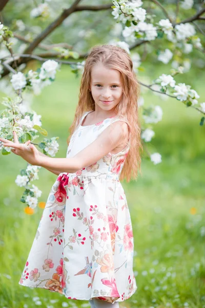 Adorable little girl in blooming cherry tree garden on spring day — Stock Photo, Image