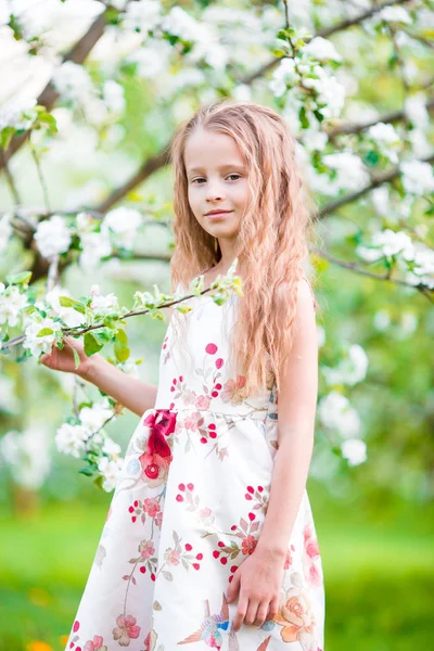 Retrato de niña en el jardín de manzanos en flor en el día de la primavera —  Fotos de Stock