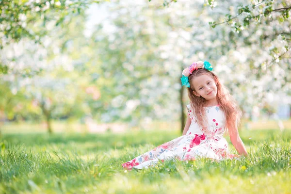 Sevimli küçük kız kiraz çiçeklenme içinde ağaç bahçe bahar gününde — Stok fotoğraf