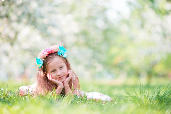 Bahar günü çiçek açan elma bahçesinde sevimli küçük bir kız. — Stok fotoğraf