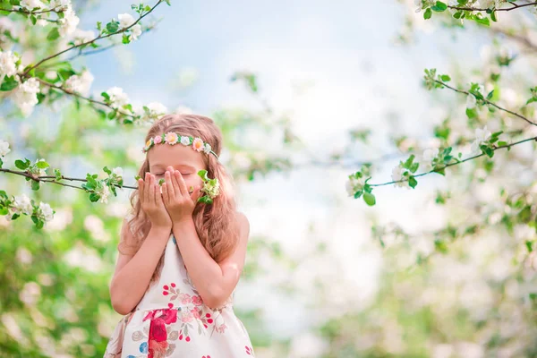 Adorable little girl enjoying smell in a flowering cherry spring garden — Stock Photo, Image