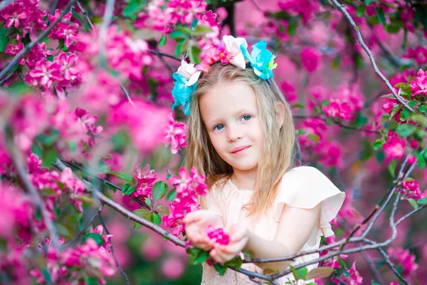 Bahar gününde çiçek açan elma ağacı bahçede, sevimli küçük kız portresi — Stok fotoğraf