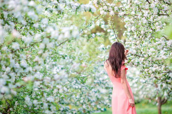 Spring mood, beautiful woman smell flowering tree, enjoying nature, white floral garden
