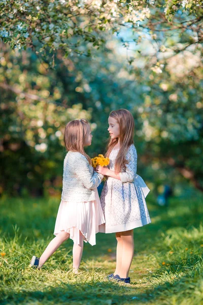 Adorabili ragazze nel giardino di mele in fiore nella soleggiata giornata primaverile — Foto Stock