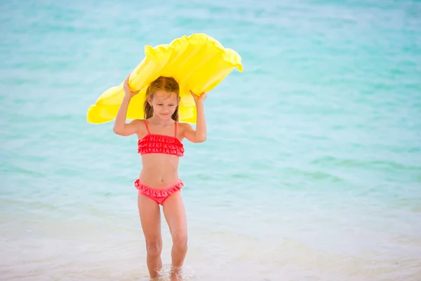 Очаровательная маленькая девочка во время пляжных каникул развлекается на мелководье — стоковое фото
