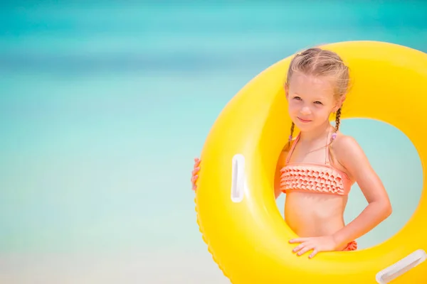 Entzückendes Mädchen mit aufblasbarem Gummiring am weißen Strand — Stockfoto