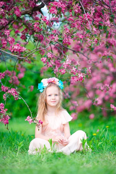 Vacker liten flicka i blommande apple tree garden utomhus — Stockfoto