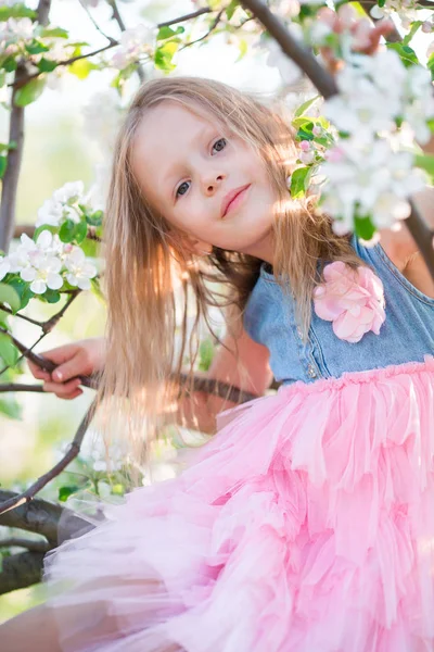 Vacker liten flicka i blommande apple tree garden utomhus — Stockfoto