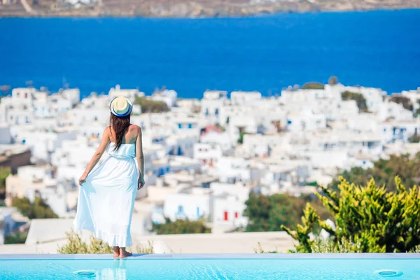 Happy girl feel freedom relaxing on the edge of pool with amazing view on Mykonos, Greece — Stock Photo, Image