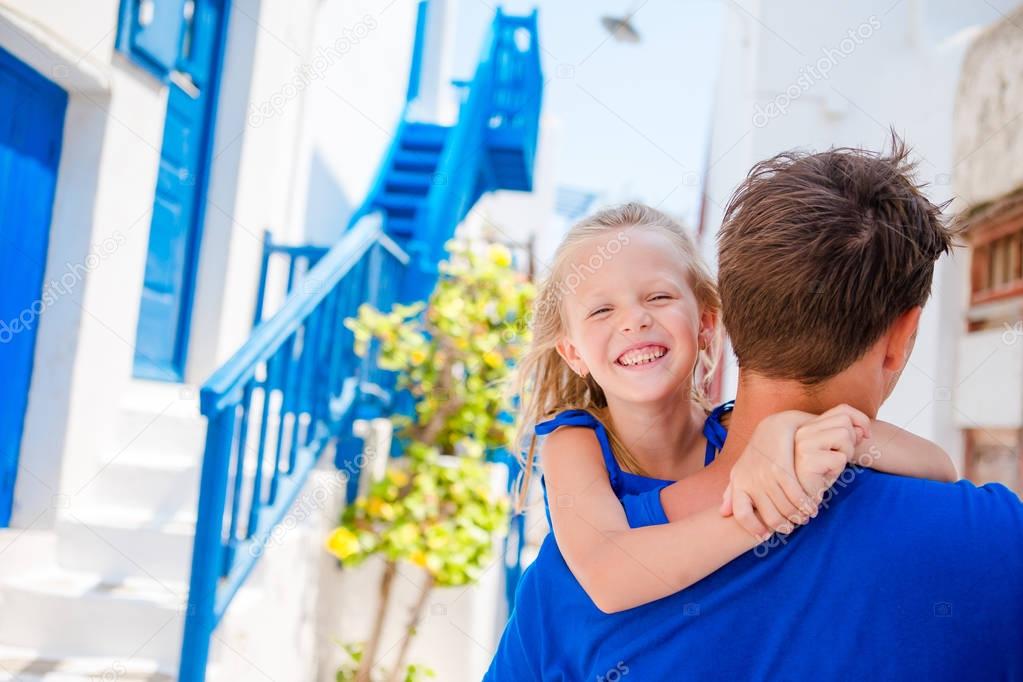 Happy dad and little adorable girl in greek village during summer vacation