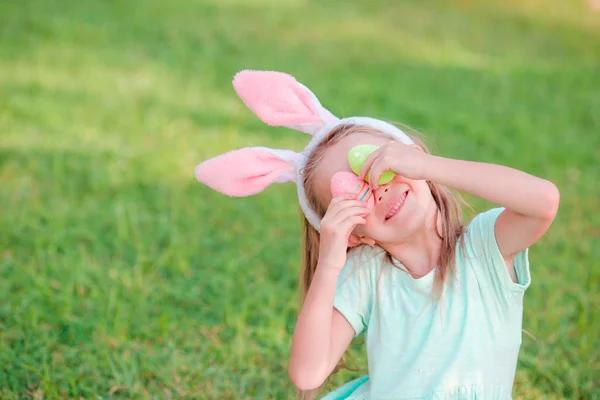 Aranyos kislány, a húsvéti ünnepet ül a fűben — Stock Fotó