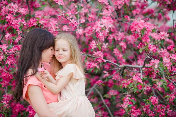 Família de mãe e criança no jardim florescendo no belo dia de primavera — Fotografia de Stock