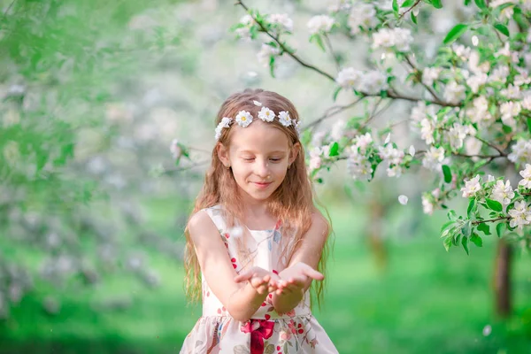 Liebenswertes kleines Mädchen im blühenden Apfelbaumgarten am Frühlingstag — Stockfoto