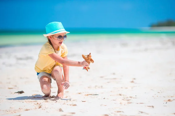 快乐的孩子女孩在沙滩上玩玩具飞机。孩子们的梦想成为一名飞行员 — 图库照片