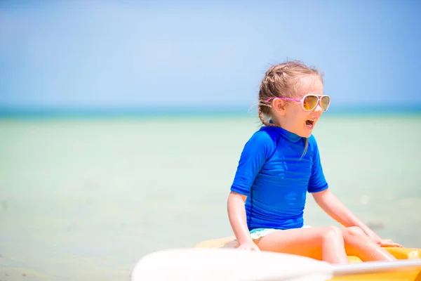 Adorable little girl kayaking and having fun on the beach vacation — Stock Photo, Image